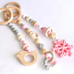 Conjunto de juguetes para el play gym en tonos gris rosa y blanco